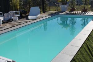 una piscina de agua azul en un patio en B&B Afrodite, en Zonnebeke
