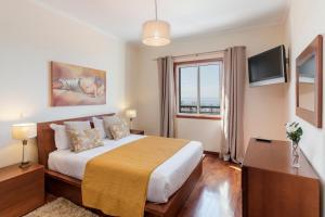 a bedroom with a large bed and a window at Ajuda III by An Island Apart in Funchal