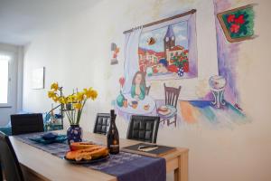 a dining room with a table and a painting on the wall at Art House Funchalet in Funchal