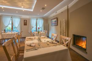 a dining room with tables and chairs and a fireplace at Kúria Beckov - Penzión in Beckov