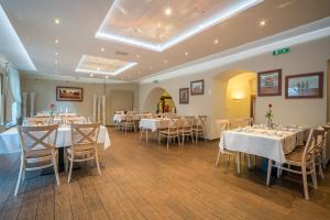 a dining room with white tables and chairs at Kúria Beckov - Penzión in Beckov