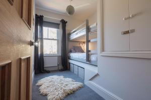 een kleine kamer met een stapelbed en een wit tapijt bij The Victorian Post House - Central Frome in Frome