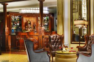 فندق غراند سافويا في جينوا: بار يوجد به كراسي وطاولة في الغرفة