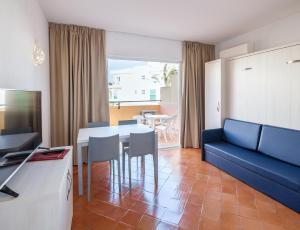a living room with a table and a blue couch at Dom Pedro Lagos in Lagos
