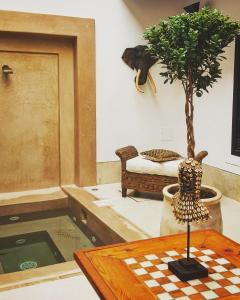 um quarto com uma mesa e um vaso de árvore em Riad Les 5 Soeurs em Marrakech