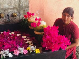 a woman standing next to a bunch of flowers at Nilaveli Ayurveda Resort in Nilaveli