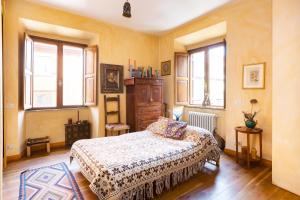a bedroom with a bed and a dresser and windows at Charming Colosseum apartment in Rome