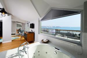 a bathroom with a tub with a view of the ocean at Hotel Poem in Istanbul +99 photos