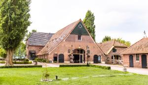 a large brick building with a green roof at Havezathe Carpe Diem in Vethuizen