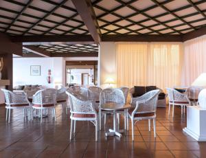 a room with wicker chairs and tables and a couch at Dom Pedro Lagos in Lagos