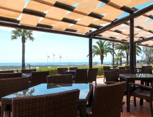 a restaurant with tables and chairs and a view of the beach at Dom Pedro Lagos in Lagos