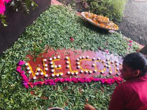 a girl standing in front of a birthday cake with flowers at Nilaveli Ayurveda Resort in Nilaveli