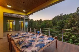 a group of tables on the balcony of a house at SaffronStays Bellini, Karjat in Kalamb