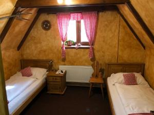 two beds in a small room with a window at Areal Salas in Kajlovec