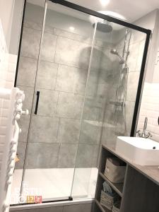 La salle de bains est pourvue d'une douche avec une porte en verre. dans l'établissement Le Studio 12, à Le Touquet-Paris-Plage