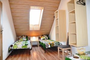 シュツァブニツァにある"Nad Zdrojami" Domek Kowalczyk 691-739-603のベッド2台と窓が備わる屋根裏部屋です。
