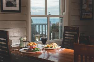 a table with two plates of food and glasses of wine at Hope & Anchor in Hope Cove