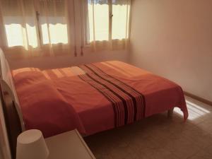 ein Schlafzimmer mit einem Bett mit einer roten Decke darauf in der Unterkunft Santis 44 in Grado