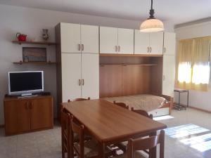 a living room with a dining room table and a television at Santis 44 in Grado