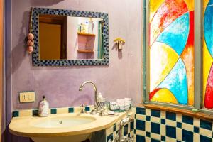 La salle de bains est pourvue d'un lavabo et d'un miroir. dans l'établissement Charming Colosseum apartment, à Rome