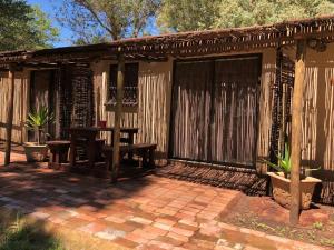 un patio con una pérgola de madera y una mesa en TreeTopia Guesthouse, en Benoni