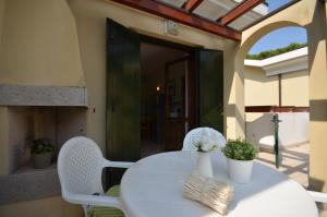 Villaggio Clio في بيبيوني: طاولة بيضاء وكراسي على الفناء