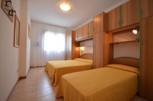 pokój hotelowy z 2 łóżkami i oknem w obiekcie Villaggio Clio w Bibione