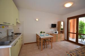 uma cozinha com um lavatório e uma mesa em Villaggio Clio em Bibione