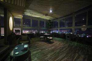 een restaurant met tafels en stoelen en uitzicht op de stad bij Wahaj Boulevard Hotel in Koeweit