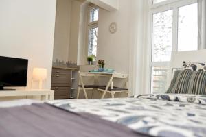 Un dormitorio con una cama, un escritorio y un televisor. en Apartamenty Zamulkowa 4TWO, en Katowice
