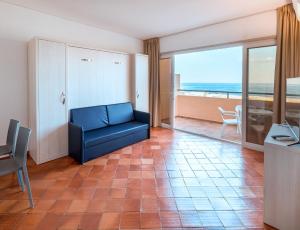 a living room with a couch and a view of the ocean at Dom Pedro Lagos in Lagos