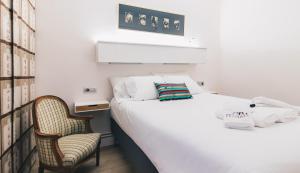 a bedroom with a bed and a chair at Urruti Apartment by People Rentals in Bilbao