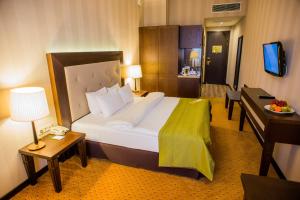 Un pat sau paturi într-o cameră la Petro Palace Hotel