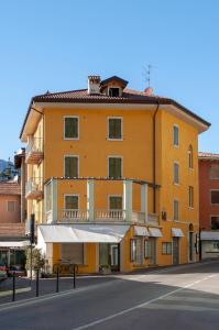 un edificio giallo sul lato di una strada di Appartamenti Baia Azzurra 4. a Torbole