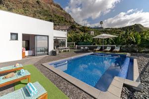 uma villa com uma piscina e uma casa em OurMadeira - Grayci's House, contemporary em Arco da Calheta