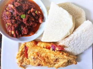 un plato de comida con un tazón de salsa y burrito en Lukeville Suites, en Abuja
