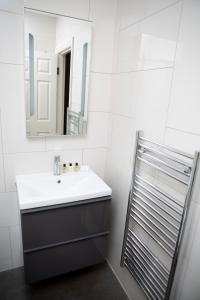 a bathroom with a sink and a mirror at Apt 1, Trafalgar Square 1st Floor by Indigo Flats in London