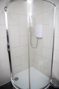 a shower with a glass door in a bathroom at Apt 1, Trafalgar Square 1st Floor by Indigo Flats in London