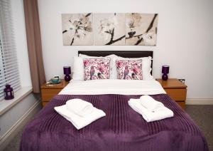 a bedroom with a bed with two towels on it at Apt 1, Trafalgar Square 1st Floor by Indigo Flats in London