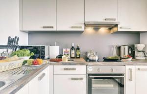 a kitchen with white cabinets and fruits and vegetables on a counter at Apartments Vea in Pula