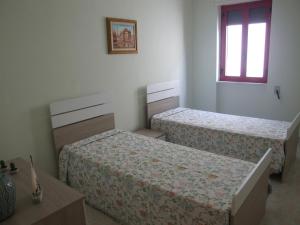 una camera da letto con due letti e una finestra di Appartamento Francesco Torre Pali a Torre Pali