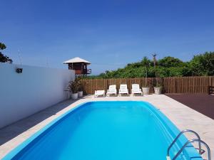 a swimming pool with chairs and a fence at AP208-COND. IDP-INGLESES -2qto in Florianópolis