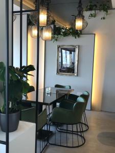 a dining room with a table and green chairs at Droushia Heights Hotel in Droushia