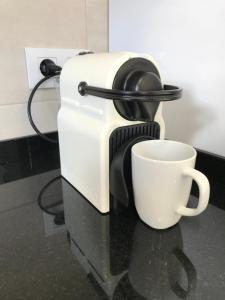 a coffee maker with a cup on a counter at Apartament L'Alba in Tossa de Mar