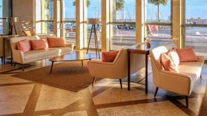 a lobby with couches and a table and windows at Real Marina Hotel & Spa in Olhão