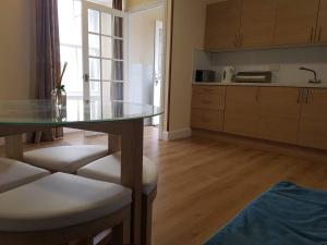 a kitchen with a glass table and some chairs at Thorshaven Apartment, Orkney in St Margaret's Hope