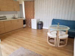 sala de estar con mesa de cristal y cocina en Thorshaven Apartment, Orkney, en St Margaret's Hope