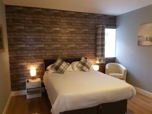 um quarto com uma cama grande e uma parede de madeira em Thorshaven Apartment, Orkney em St Margaret's Hope