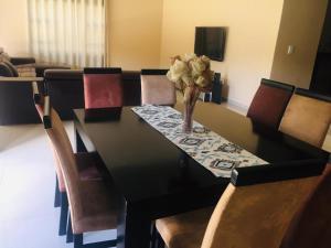 a dining room table with a vase of flowers on it at DeTlous BnB in Empangeni