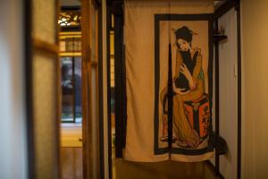 ein Bild einer Frau auf einem Vorhang an einer Tür in der Unterkunft Kyomachi Yumeji in Kyoto